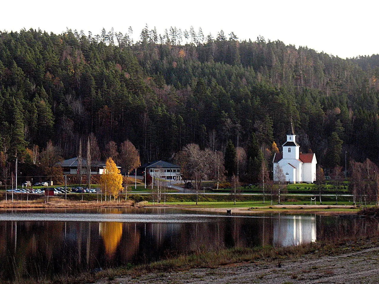 Grenda Iveland ved Birketveitstjønna med kyrkja og skulen. Svintoksknutten i bakgrunnen.
